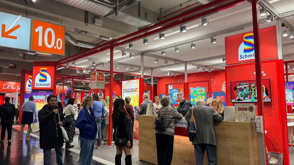 Abgebildet sind mehrere Personen am Messestand von Schmidt Spiele.